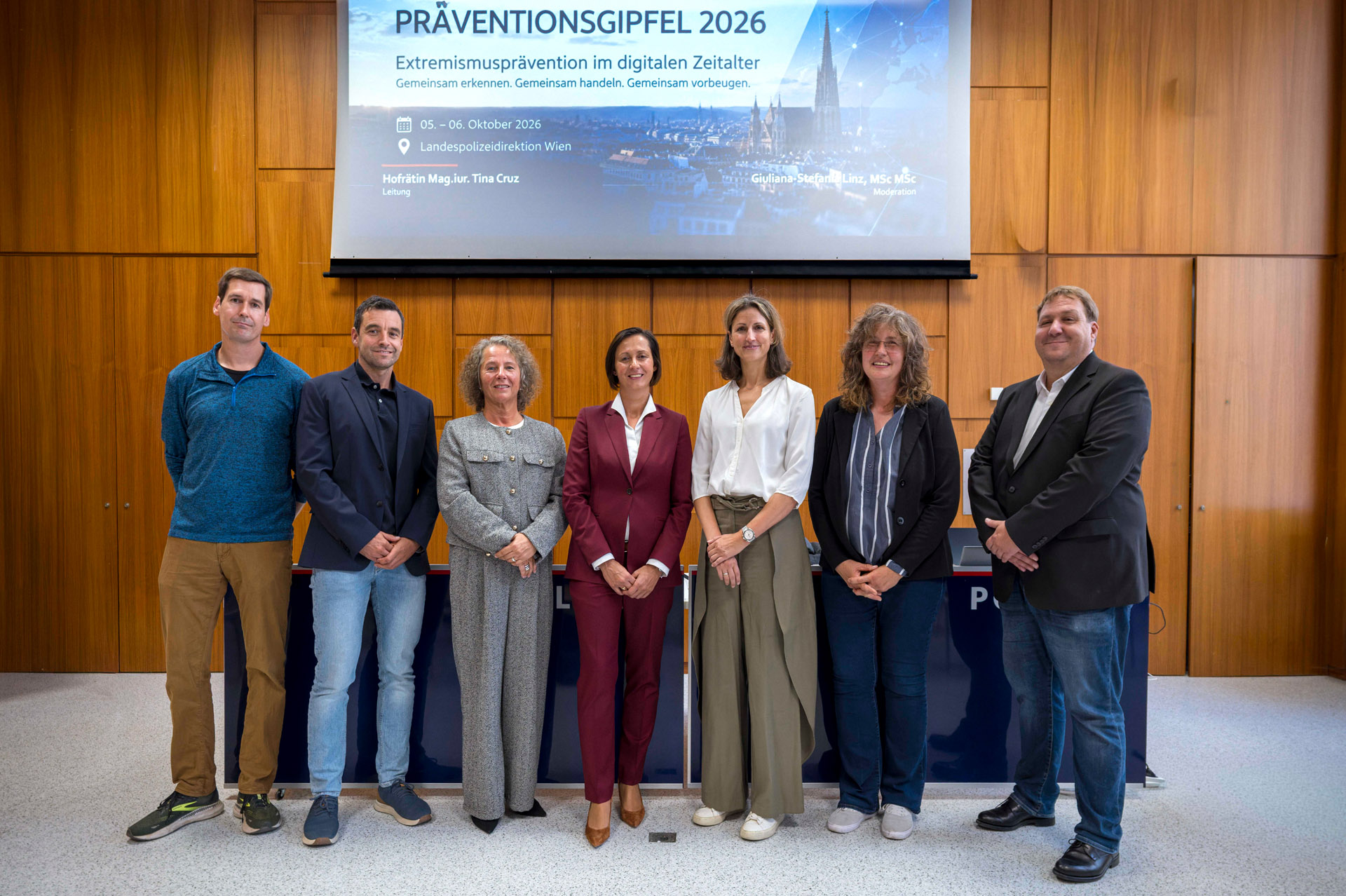 Gruppenfoto beim Präventionsgipfel 2026 in der Landespolizeidirektion Wien vor der Veranstaltungsleinwand.